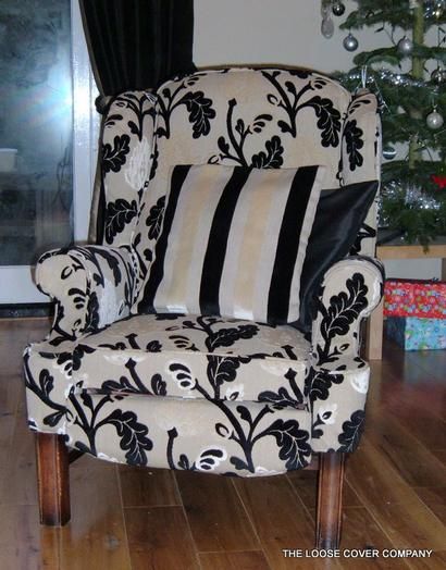 Armchair in a black and cream floral loose cover with a striped cushion