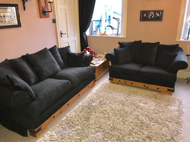 Two black sofas with new fitted loose covers