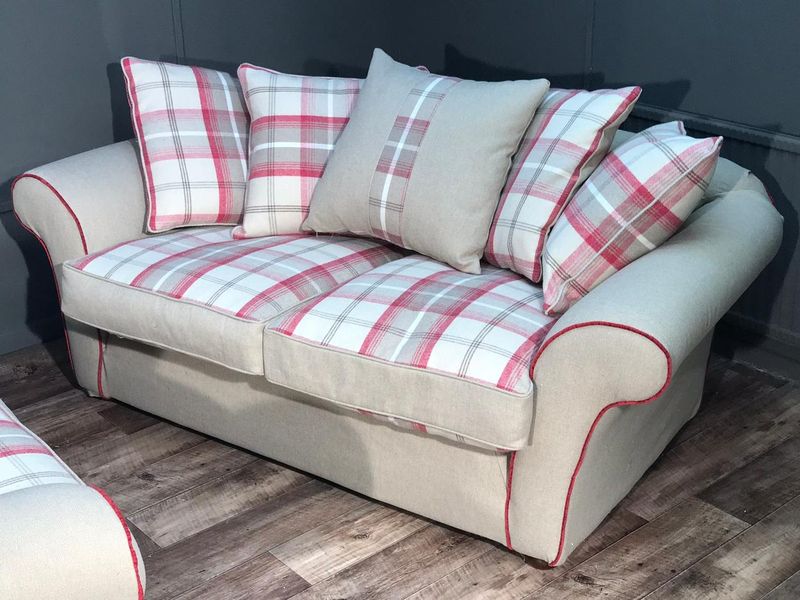 Caravan sofa in cream fabric with red piping and check cushions