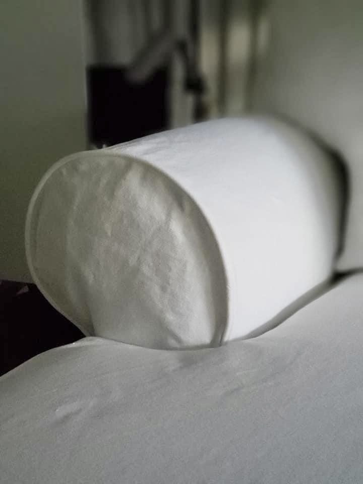 Close-up of the white bolster cushion cover on Frances's chaise