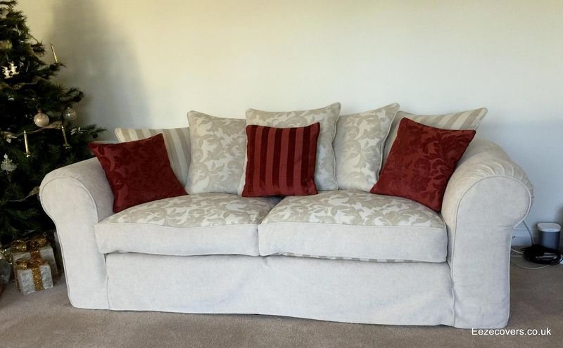 Cream damask sofa loose cover with red scatter cushions