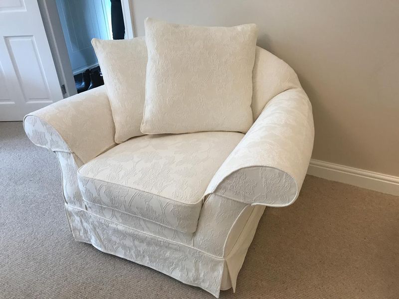Snuggler chair in a cream loose cover with a tailored skirt