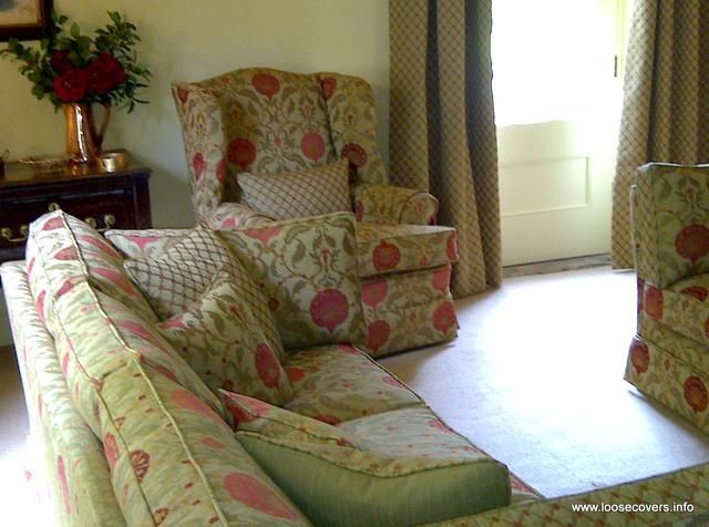 Sofa and wing chair in floral loose covers with green piping