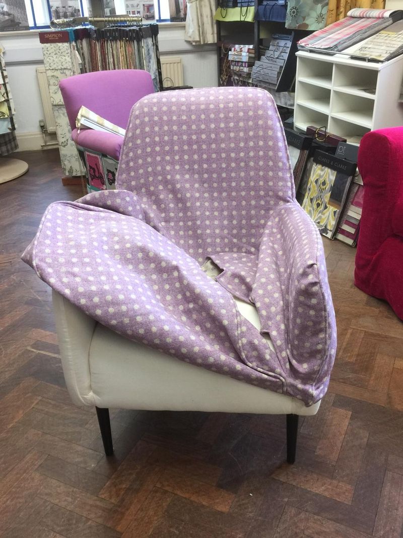Lilac patterned fabric being fitted on an armchair