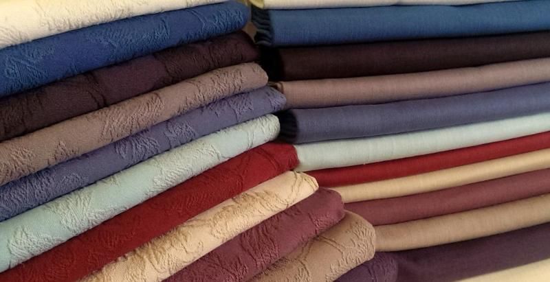 Folded loose cover fabrics in reds, blues and neutrals