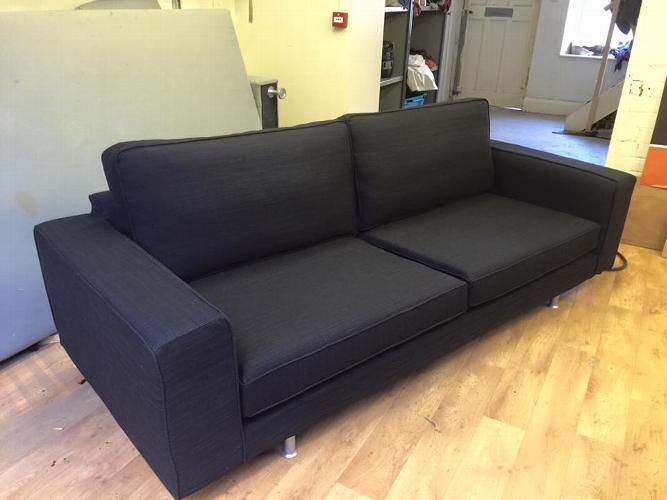 Modern three-seater sofa in a dark replacement loose cover