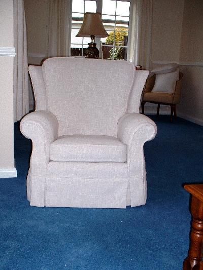 Armchair in a pale damask loose cover with a skirt