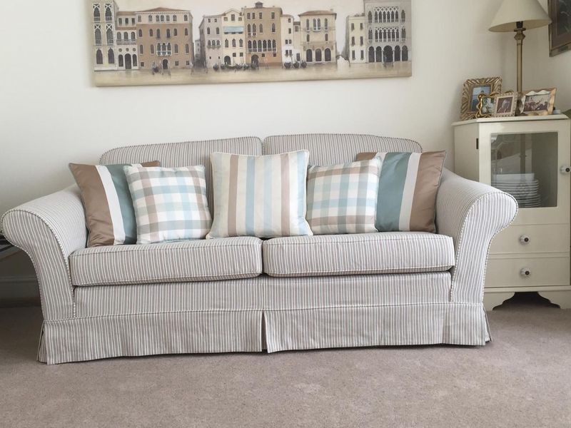 Sofa in a pale striped loose cover with a tailored skirt