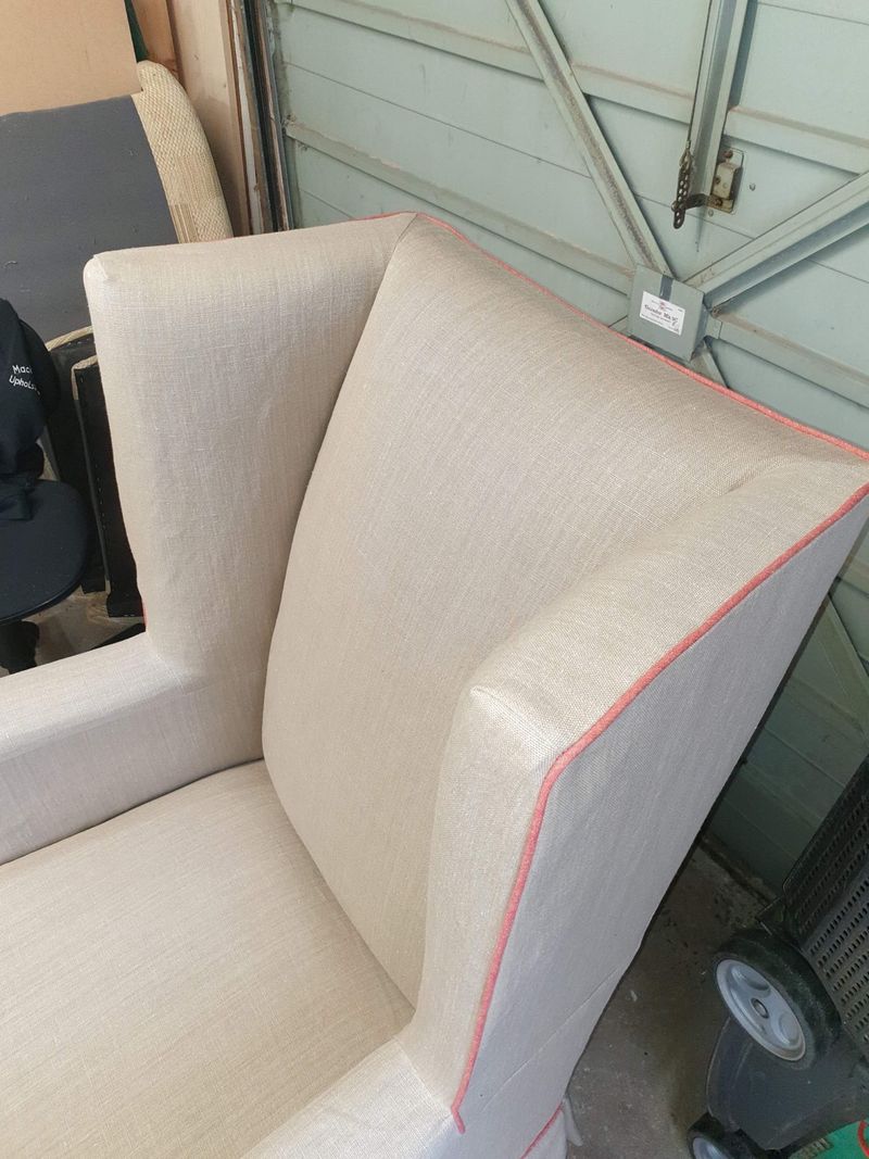Wing chair slipcover in oatmeal fabric with pink piping
