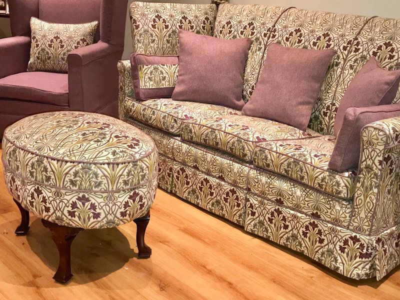 Sofa, footstool and armchair in matching traditional print loose covers