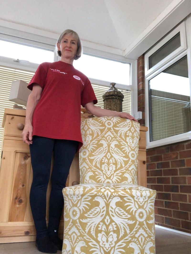 Sonia standing beside her gold damask chair cover