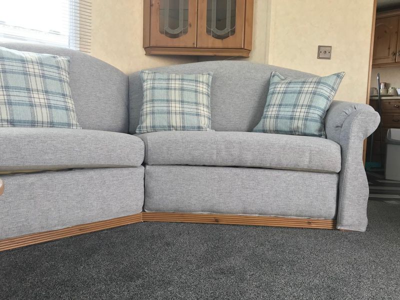 Static caravan corner sofa recovered in grey with check cushions