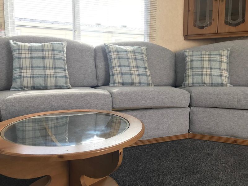 Static caravan corner seating with new grey covers and check cushions
